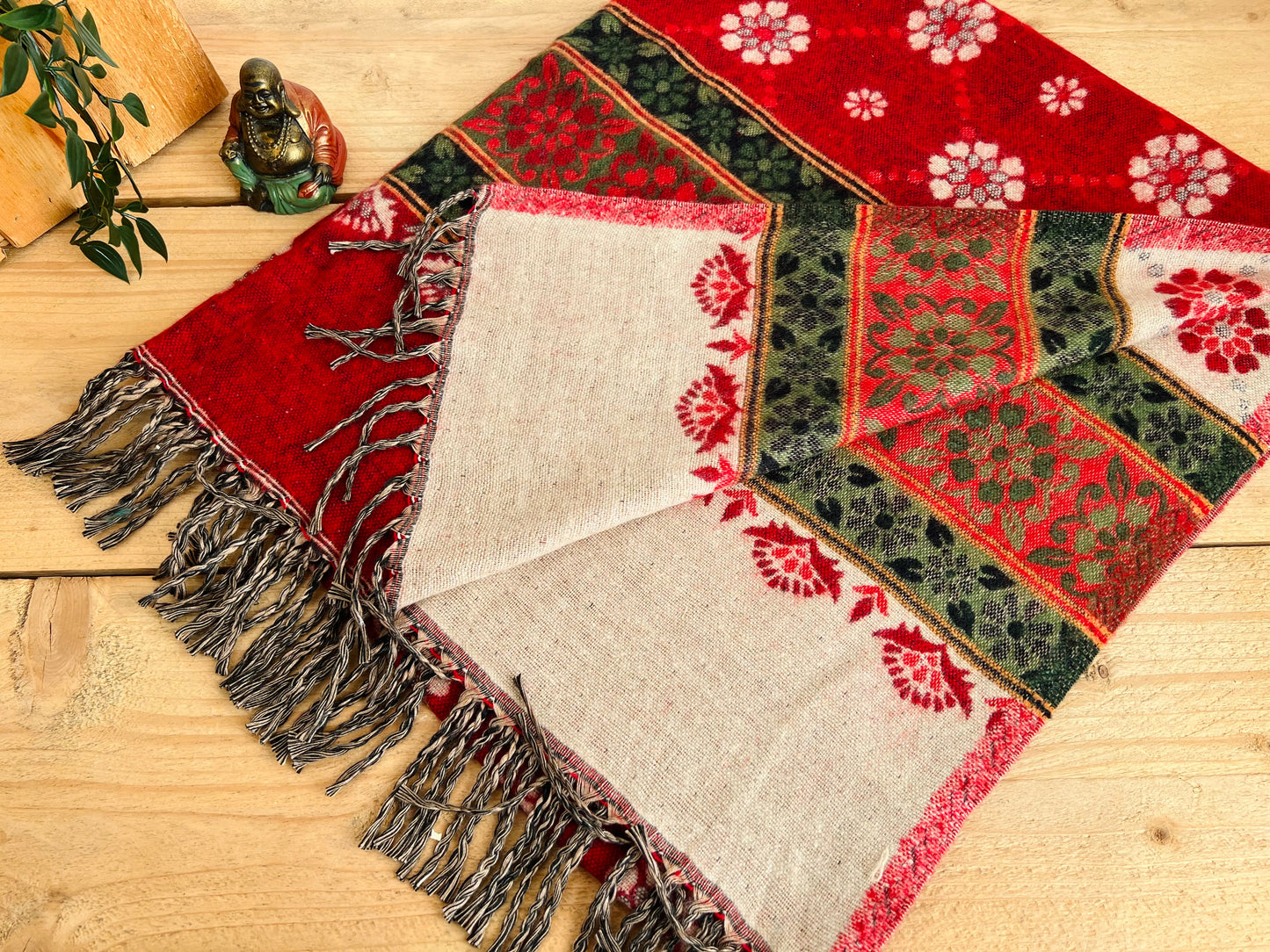 Boho handwoven red throw blanket draped over sofa with fringe detailing