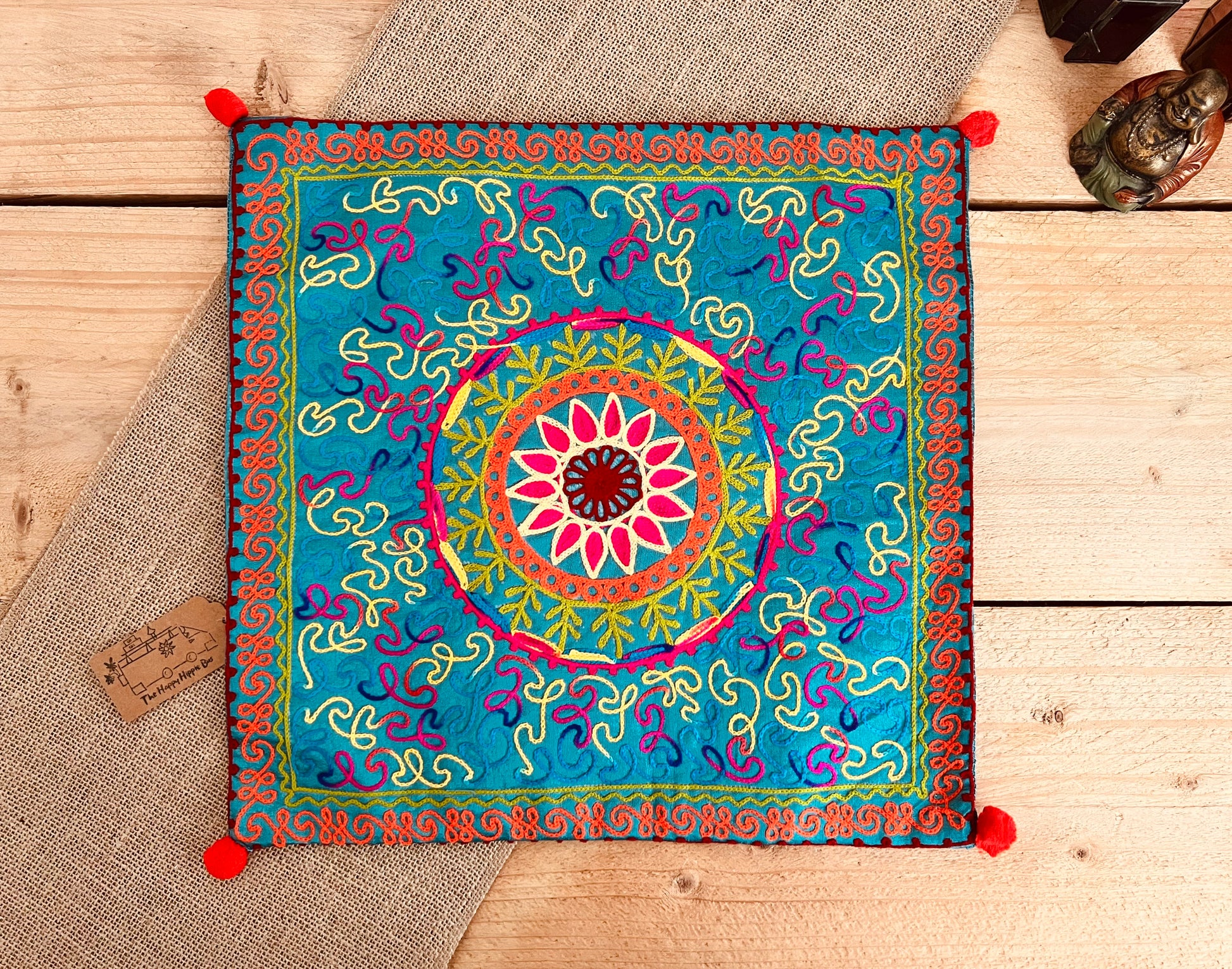 Sky blue flower vibrant silk style fabric cushion covers with hand embroidered boho hippie chic pattern designs in three vibrant colours with Pom Pom edge detail, handmade fair trade & ethical