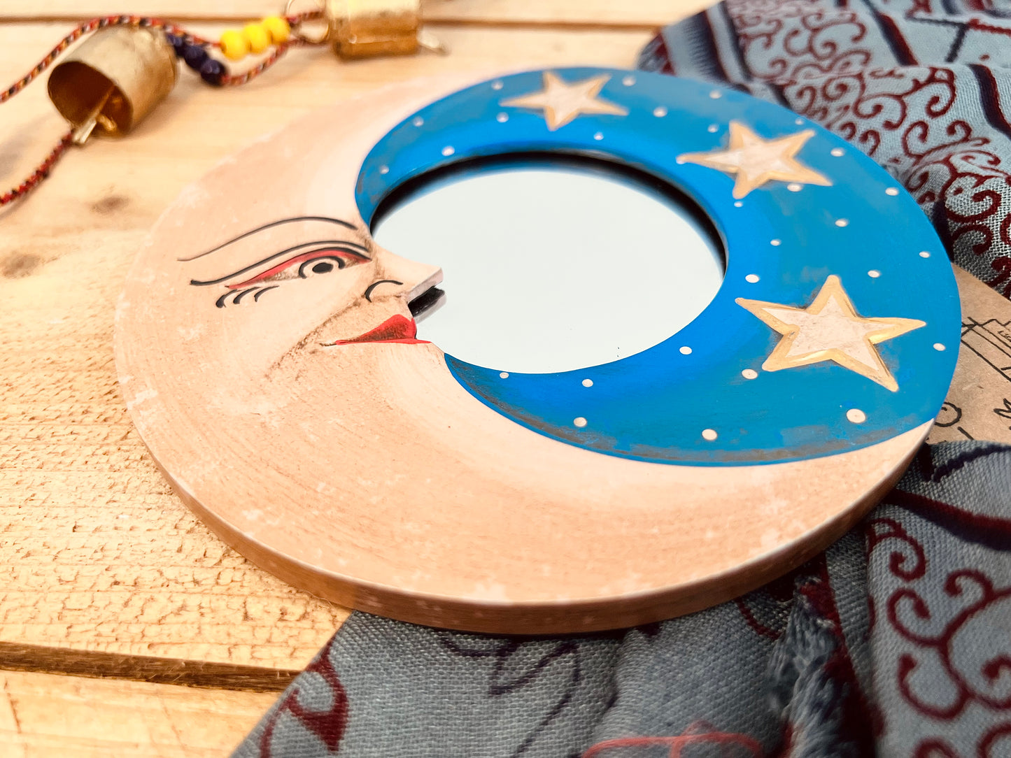 Round glass mini wooden wall hanging mirror close up with hippie boho moon & stars detailing in blue & yellow colour. Bohemian vintage style rustic finish small mini round wooden framed mirror. Handmade, Fair Trade, Ethical, Sustainable home decor.