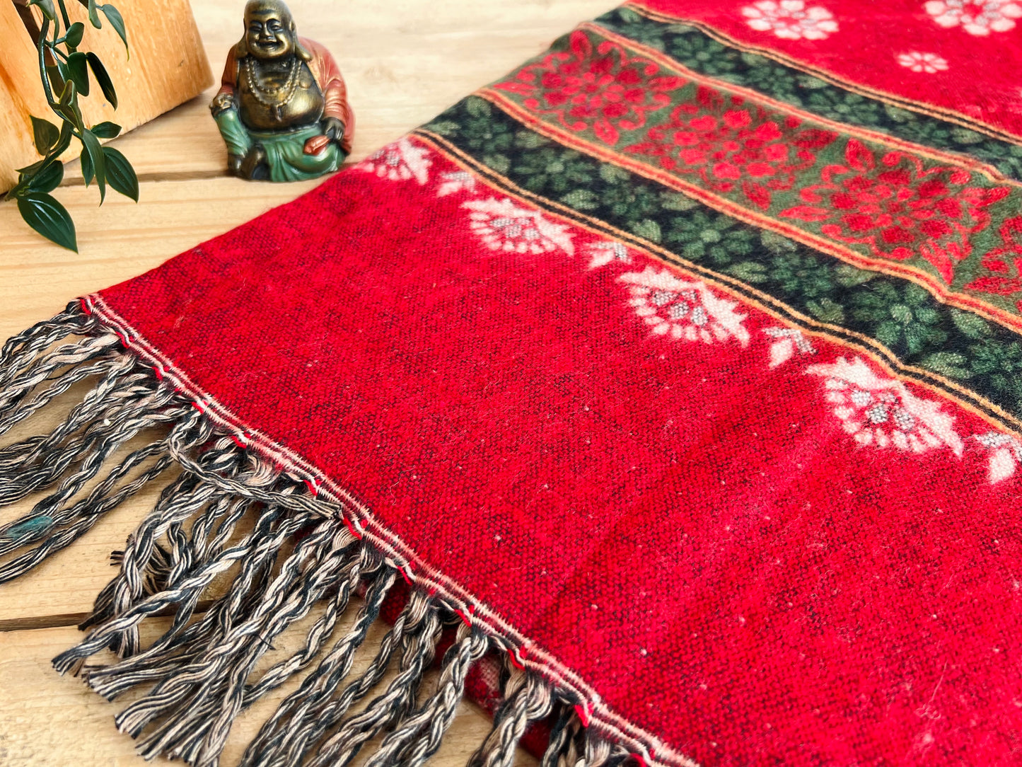 Ethical fair trade boho throw blanket folded to show floral pattern and tassels