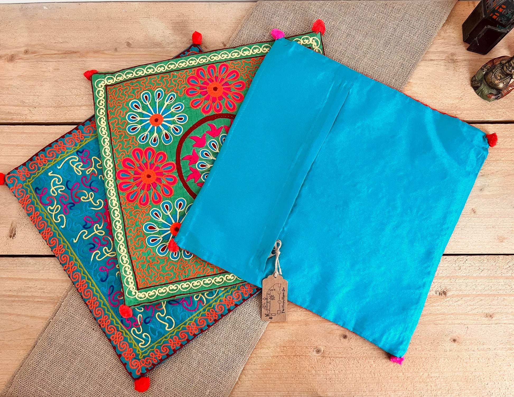 vibrant silk style fabric cushion covers with hand embroidered boho hippie chic pattern designs in three vibrant colours with Pom Pom edge detail, handmade fair trade & ethical