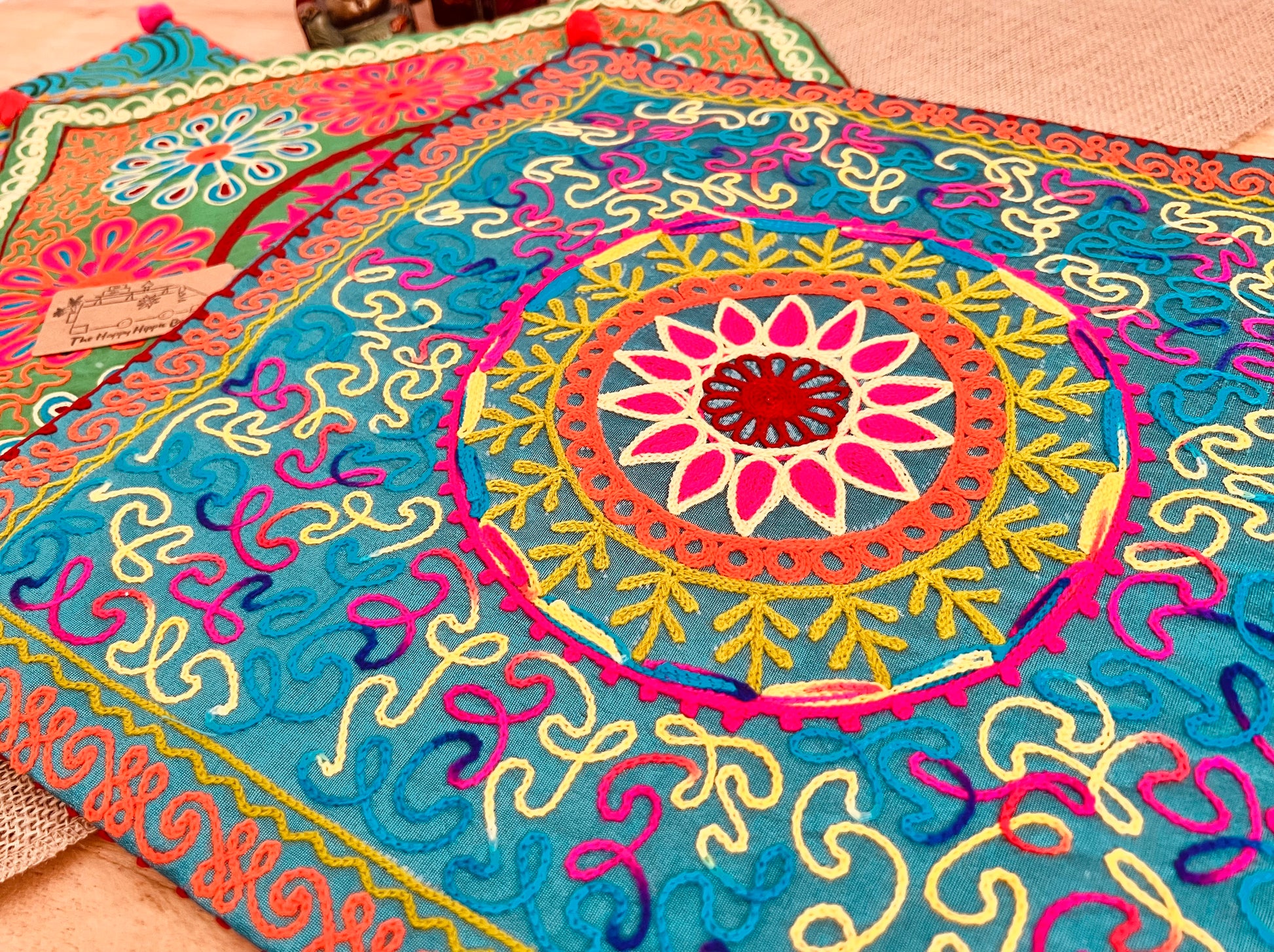 Fine wool embroidery vibrant silk style fabric cushion covers with hand embroidered boho hippie chic pattern designs in three vibrant colours with Pom Pom edge detail, handmade fair trade & ethical