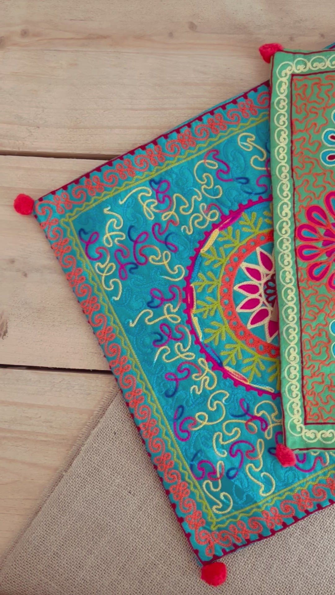 vibrant silk style fabric cushion covers with hand embroidered boho hippie chic pattern designs in three vibrant colours with Pom Pom edge detail, handmade fair trade & ethical