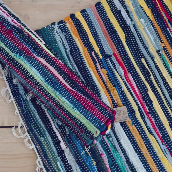 handmade fair trade recycled dark blue rag rug with tassels, small sized mini rag rug, multi coloured cotton rug, boho hippie bohemian home decor rug ethically sourced